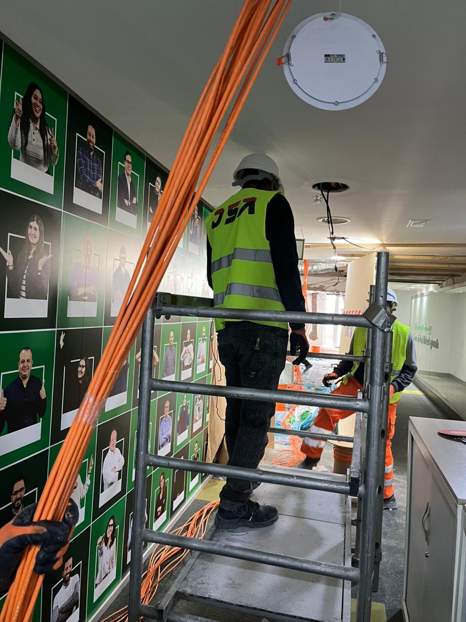 Tirage de câbles orange sur échafaudage dans une cage d'escalier