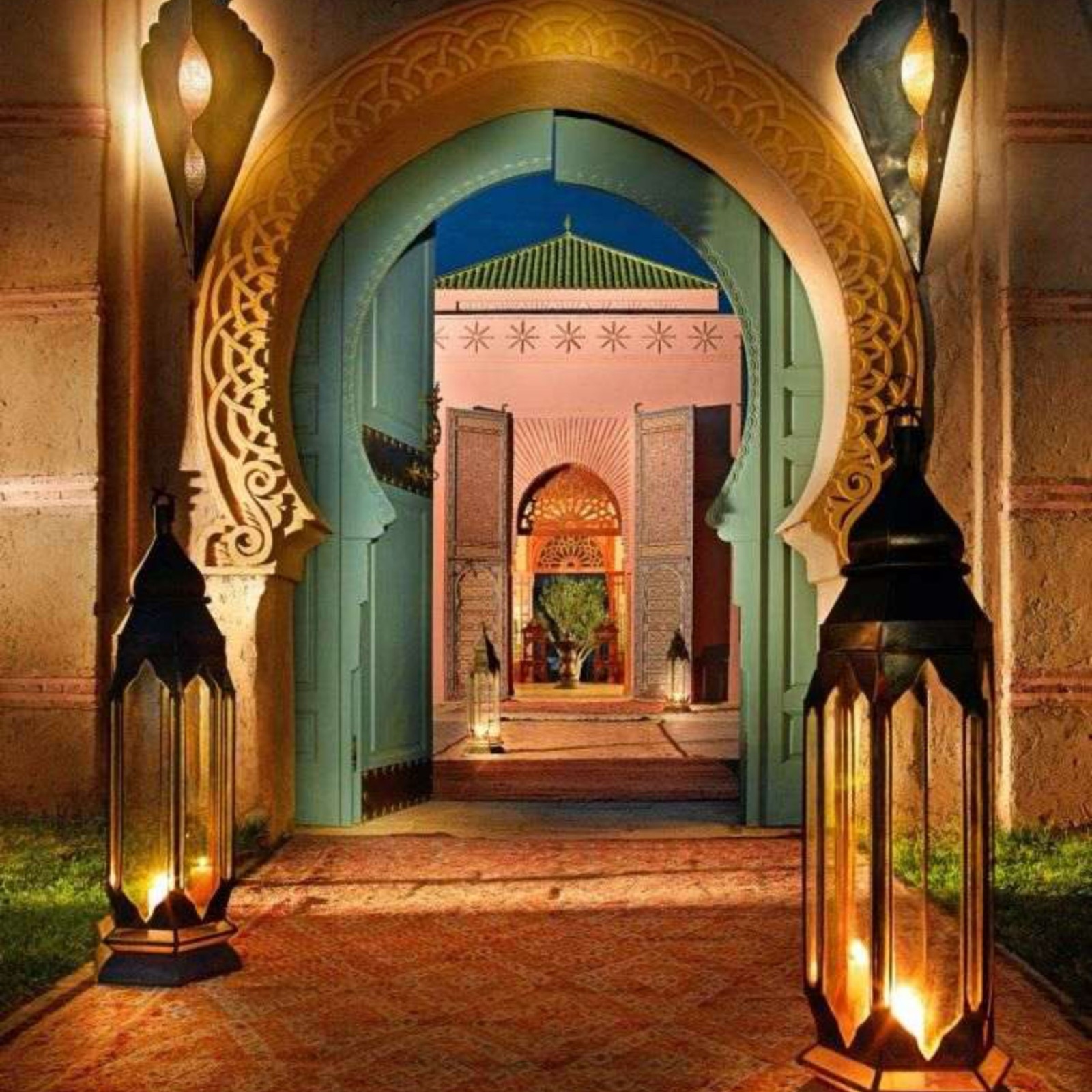 Porche d'entrée d'hôtel marocain avec arche mauresque et lanternes traditionnelles suspendues